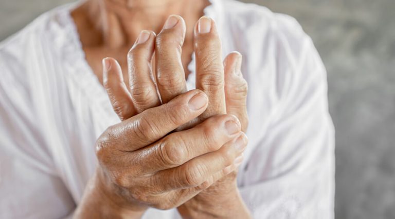 an elder lady holding her one hand with other hand
