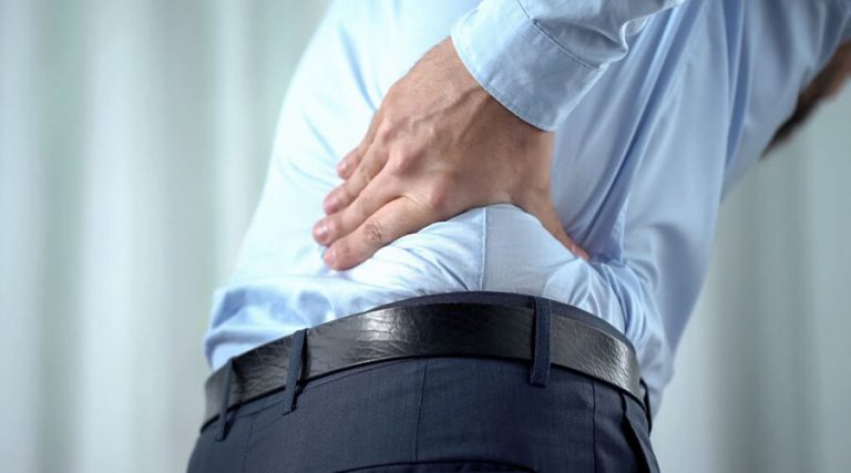 a man holding her lower back in discomfort