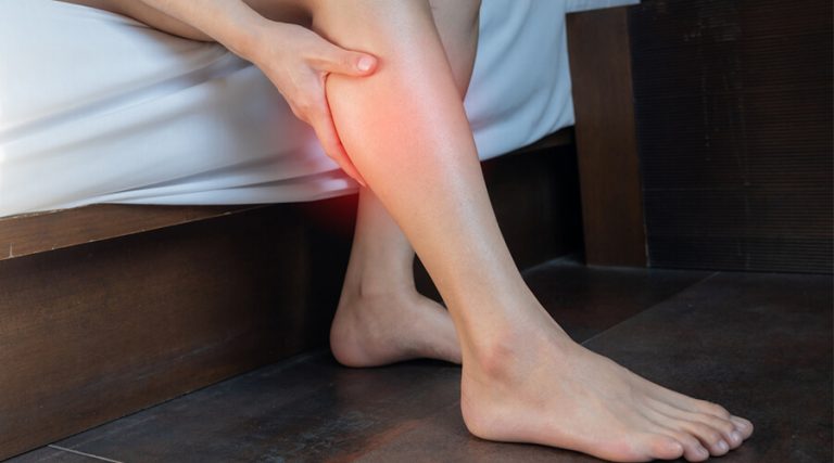 A girl is sitting on a bed, relaxing.