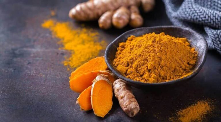Image of an turmeric powder along with Turmeric root.
