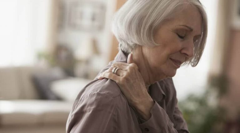 an old lady kept her hand on shoulder were experiencing shoulder pain