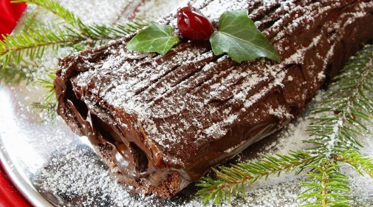 A delicious chocolate log cake were garnish out with cherry