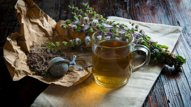 A catarrh tea and its dry leaves were kept on a wooden table