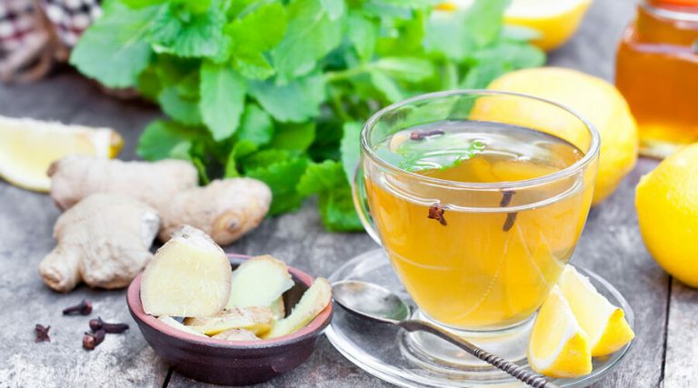 A Ginger Lemonade tea were kept in a cup along with lemons and ginger