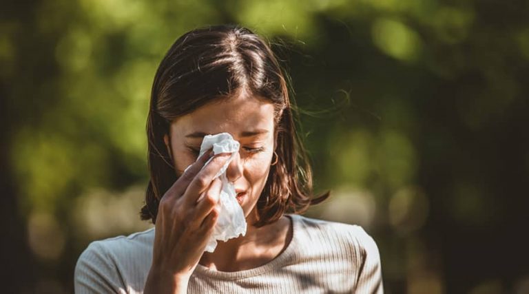 A girl crying and gently wiping her tears with a tissue, expressing sadness or emotional distress