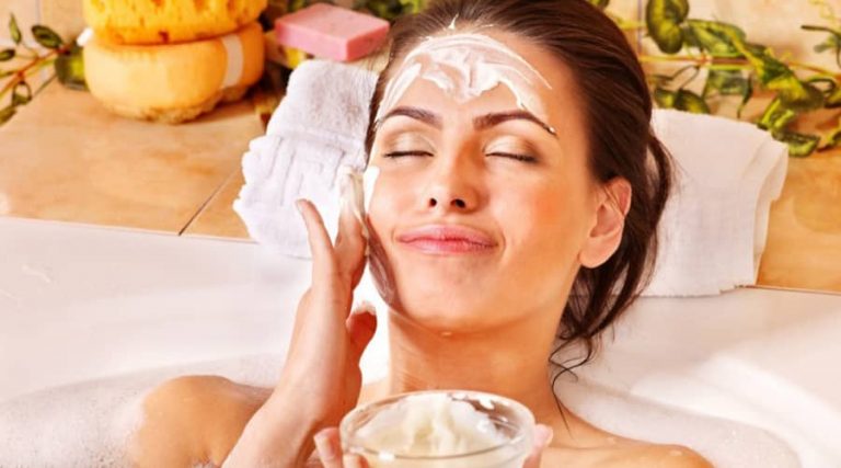 A girl carefully applying a face mask, suggesting a relaxing selfcare routine