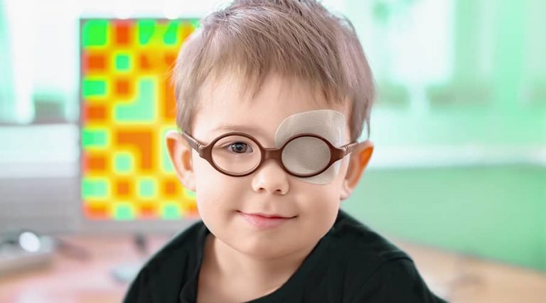 A child wearing glasses with a bandage over one eye.