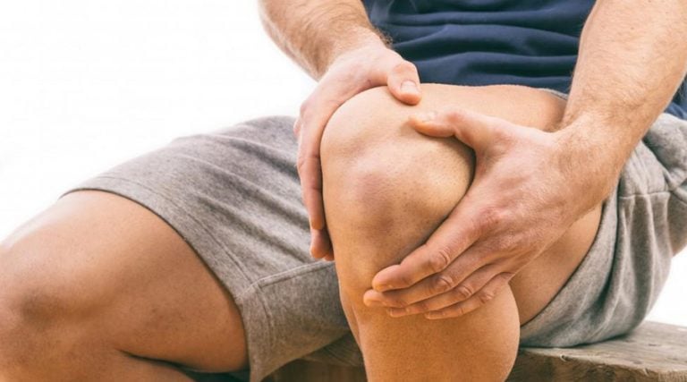 man holding his knee in pain