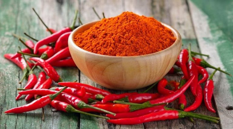 a bowl of hot pepper with red chilli's on table