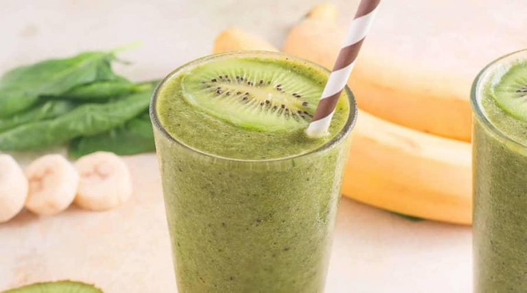 a glass filled with birdweed juice served with kiwi and a straw