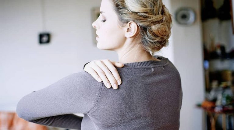 a blonde woman showing her back with her hand placed on shoulder