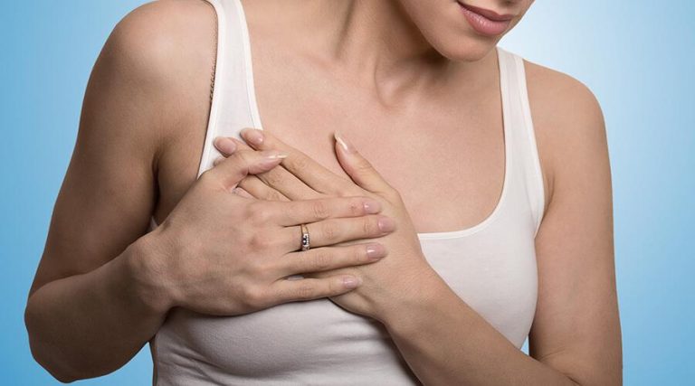 young lady placing hand on her chest. having pain in the chest