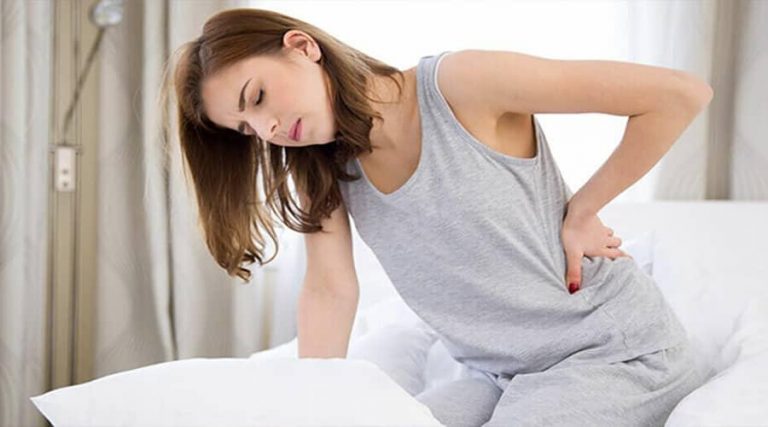 a young lady holding her back in pain