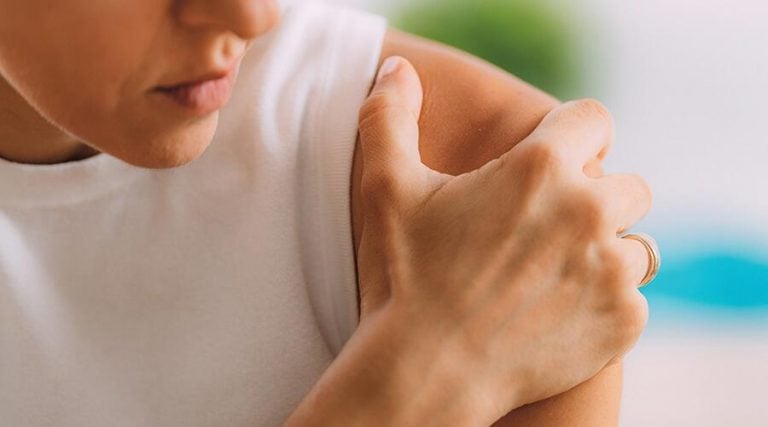 a women holding her shoulder in pain