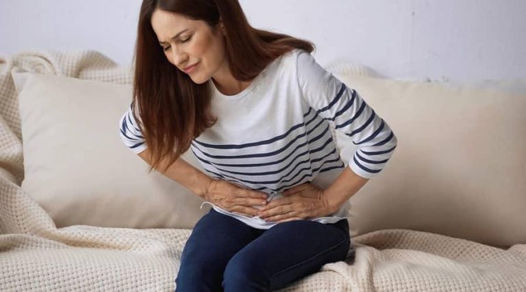 a young women holding her stomach in pain