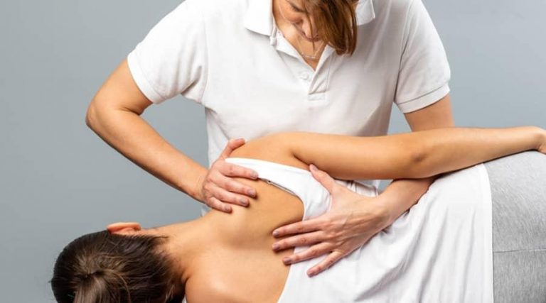 a masseuse massaging shoulder of another person