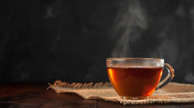 a cup of hot tea placed on a wooden table