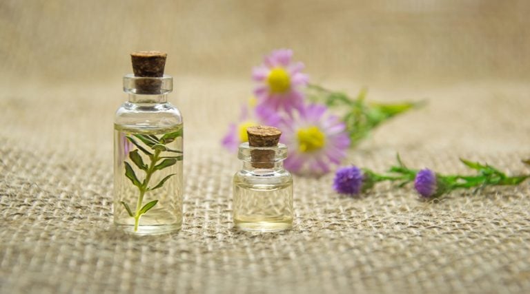 a bottle of essential oil placed on a jute surface