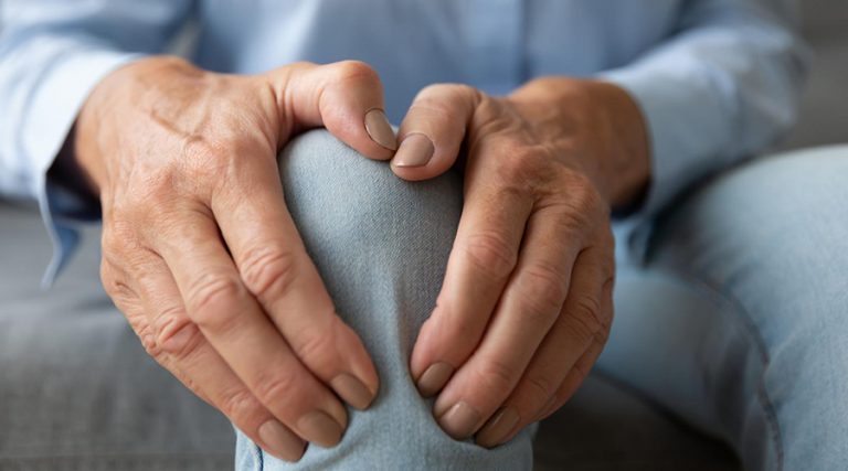 old man holding his knee in pain