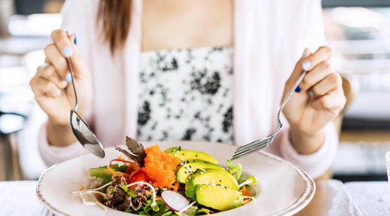 a women eating a Healthy Balanced Meal with avacado and vegetables