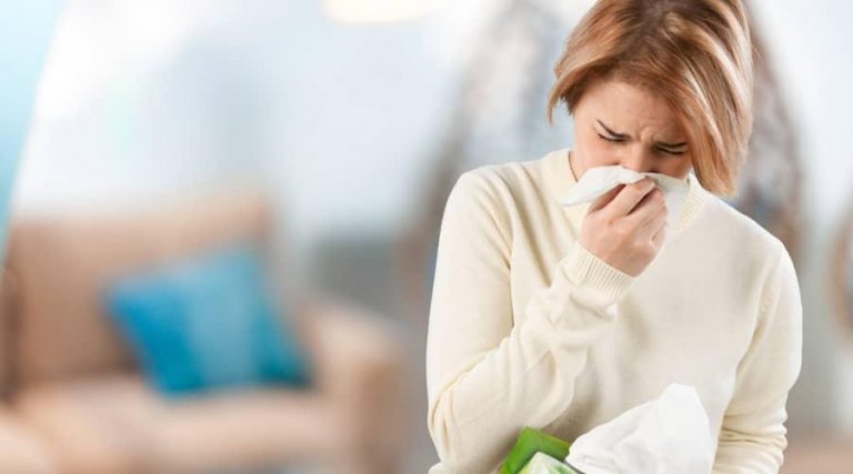 women with allergy wiping her nose with a tissue